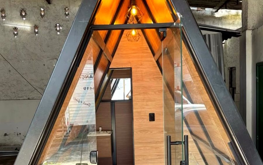 Chalé A-frame de 13 m² com varal de lâmpadas, fachada de vidro e deck em madeira de lei